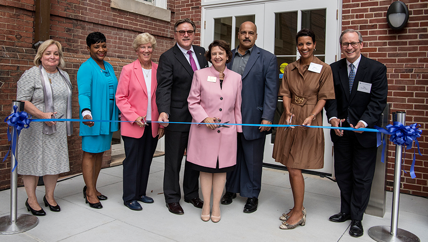 NDMU representatives and distinguished guests cutting the ribbon in front of Gibbons Hall