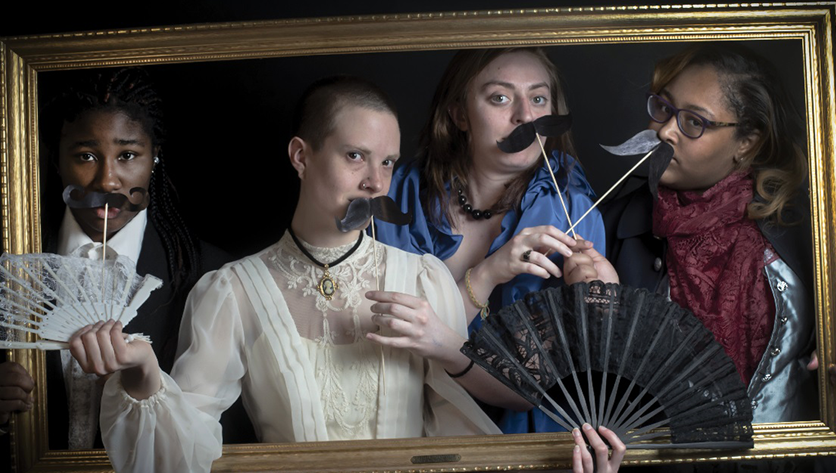 Photo Credit: Cassidy Toulan Actresses in a picture frame holding props and wearing historical clothing