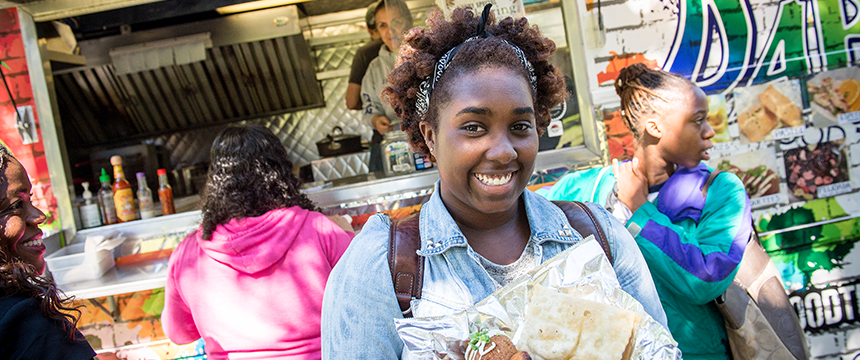 Girl with food in front of a food truck