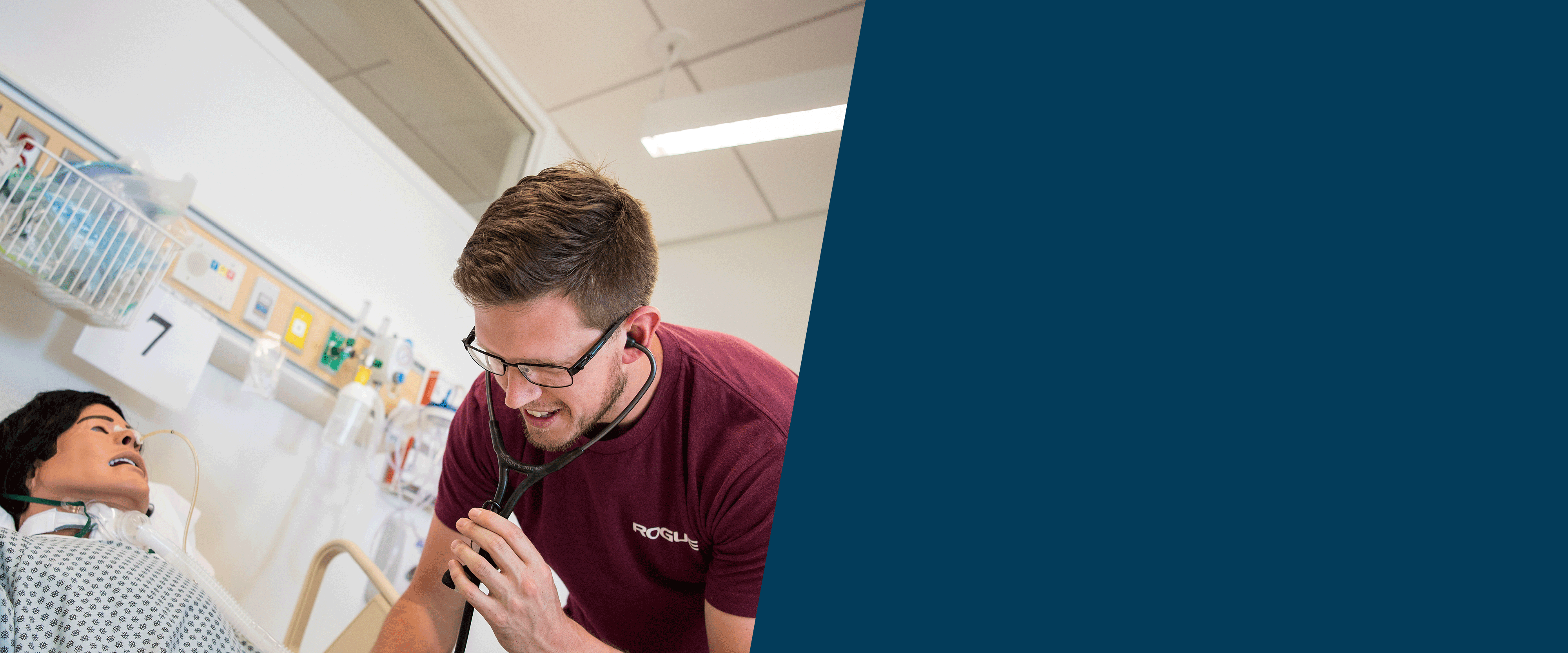 male nursing student with stethoscope checking the manikin