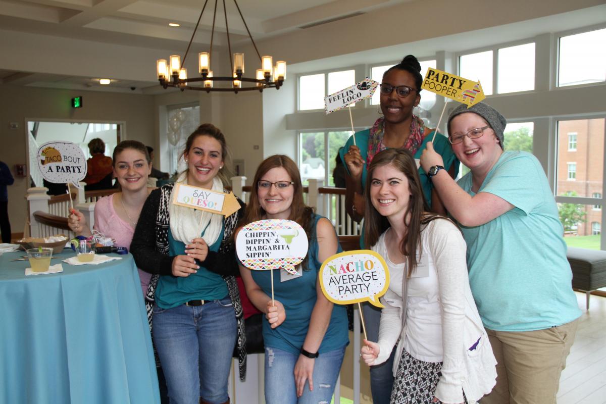 Nursing students at a party holding funny signs