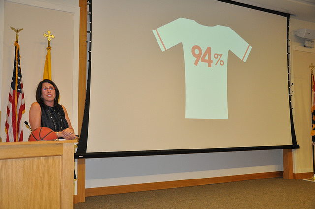 Donna Orender standing at podium with basketball