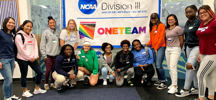 group of student athletes next to NCAA One Team banner