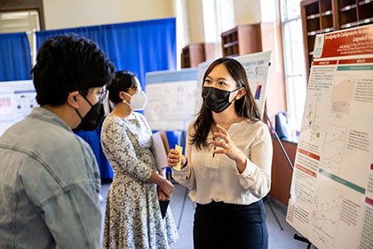 student explaining poster in research day