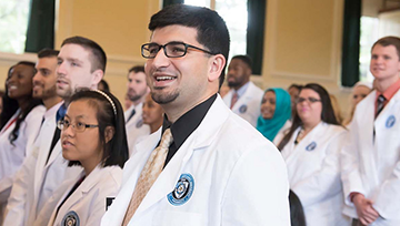 Group of student pharmacists standing with white coats