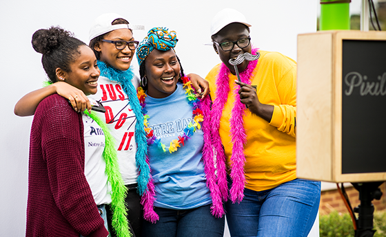 students wearing silly props in a photobooth