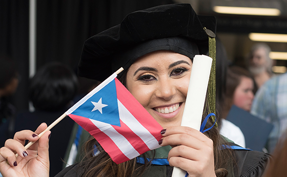 Female Pharmacy Graduate holding her country's flag