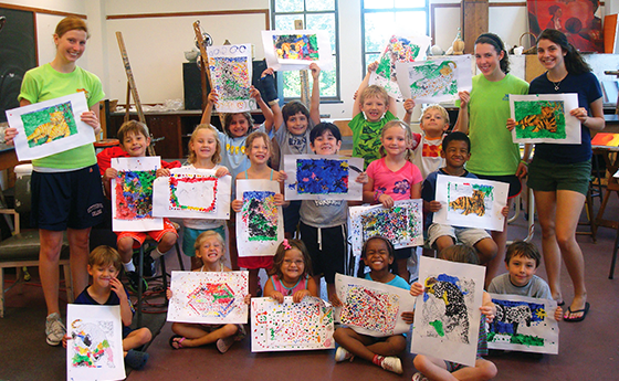 Kids and teachers holding artwork