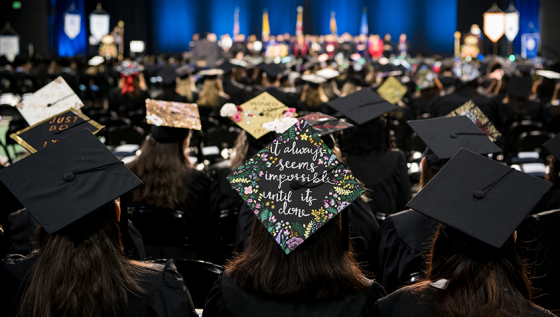 Back of crowd of students wearing caps