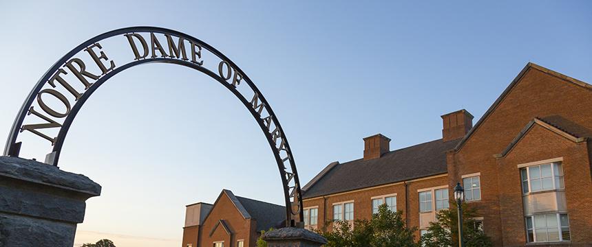 "Notre Dame of Maryland" displayed in arch on the left side, and a brick building on the right side