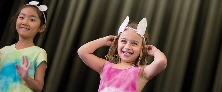 Two little girls on stage wearing bunny ears
