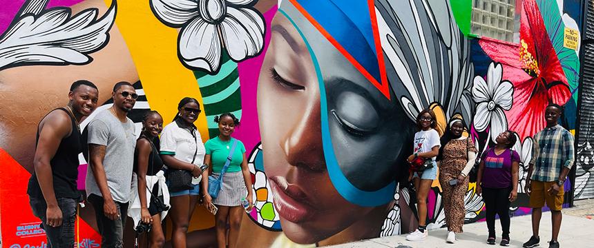 a group of people in front of painted wall