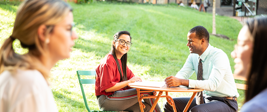 Diverse group of students sitting outdoors on campus