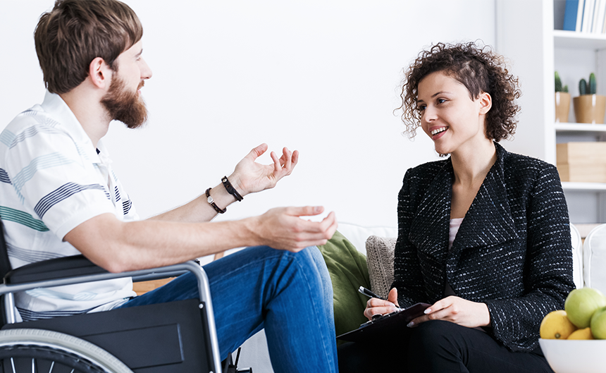 Man in a wheel chair talking to a therapist