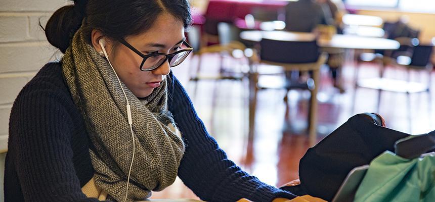 Student wearing headphones and reading